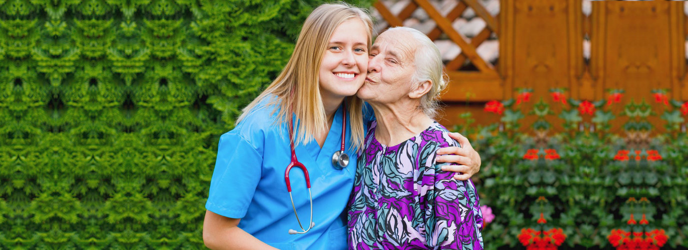 senior woman kissing a caregiver