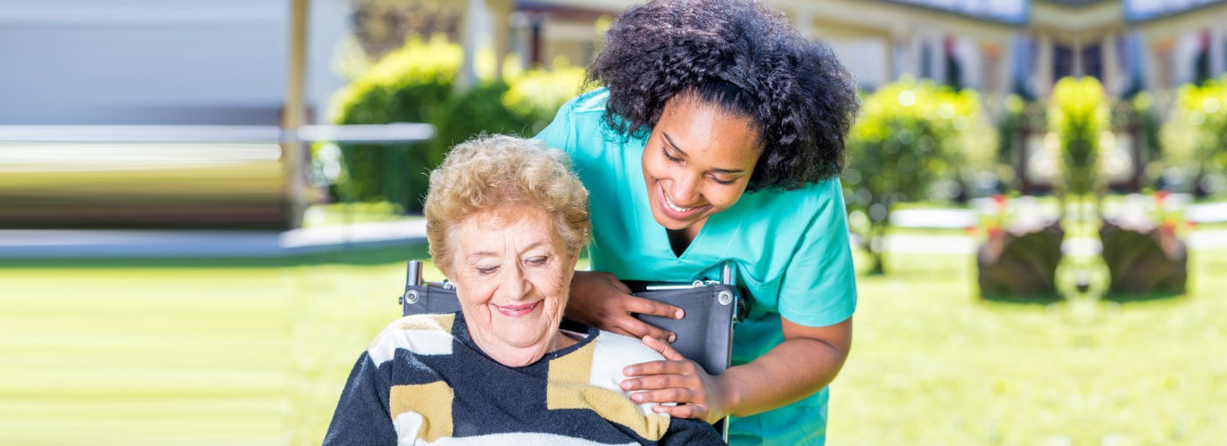 caregiver and senior woman looking at a tablet